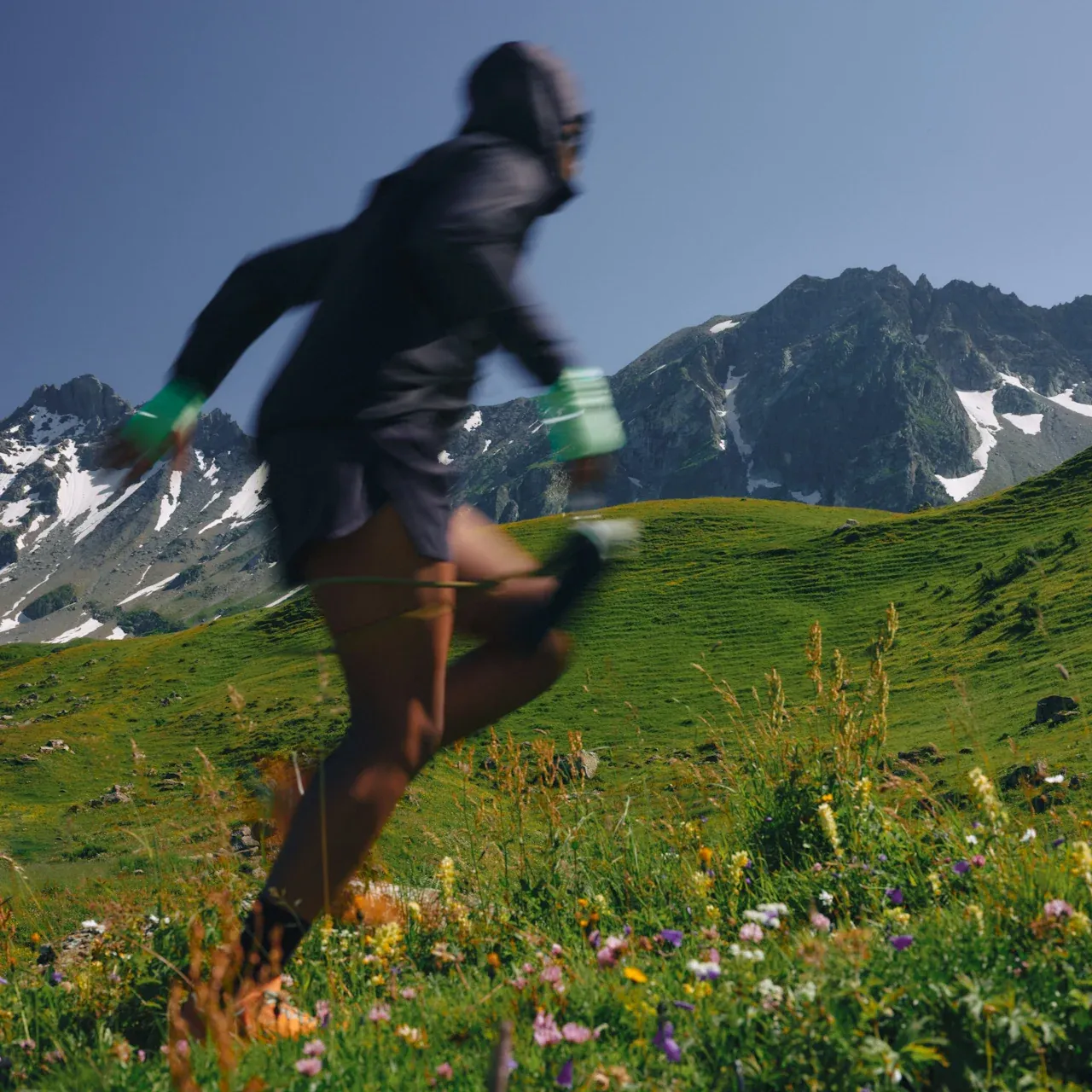 A person trail running through a mountain meadow